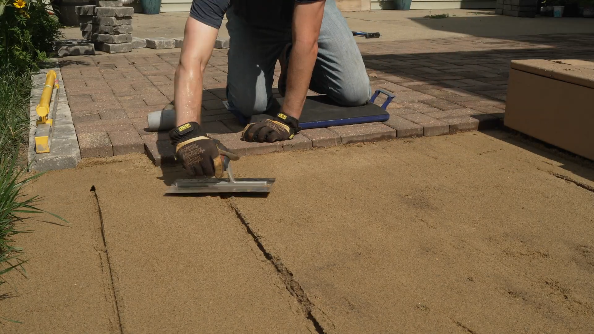 man smoothing sand with finishing trowel
